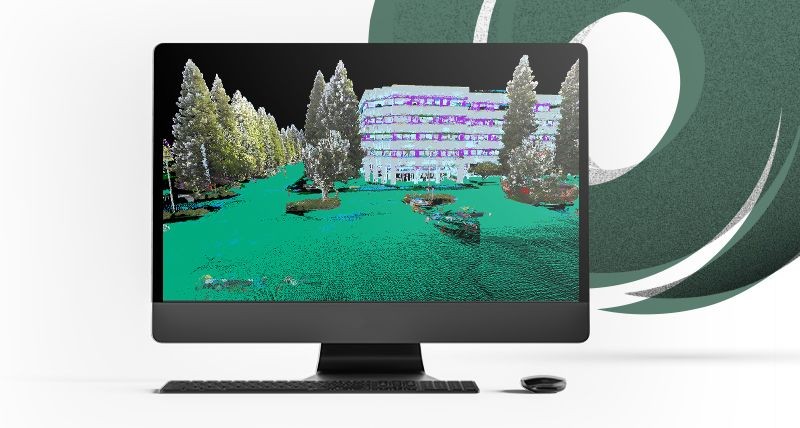 Desktop computer displaying a 3D rendering of a building surrounded by trees and green landscape.